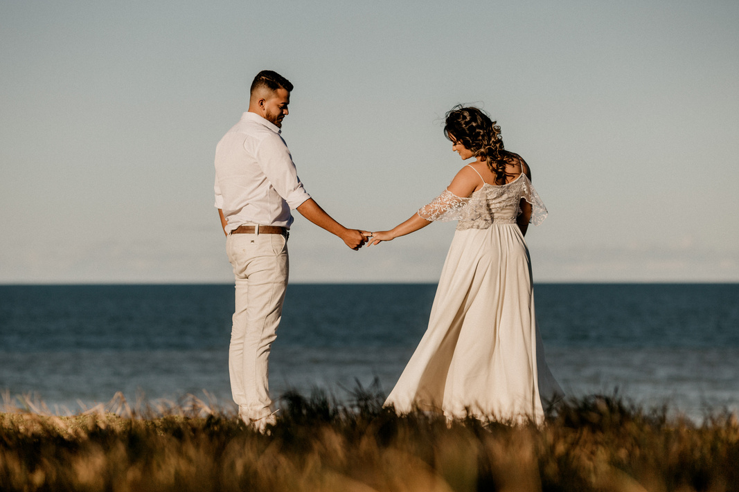 Loving ethnic couple dancing on beach on wedding day